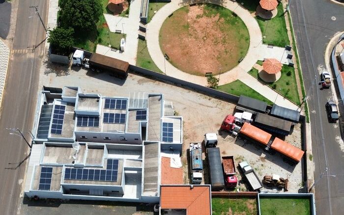 Aerial city view highlighting solar panels and green spaces on a sunny day.